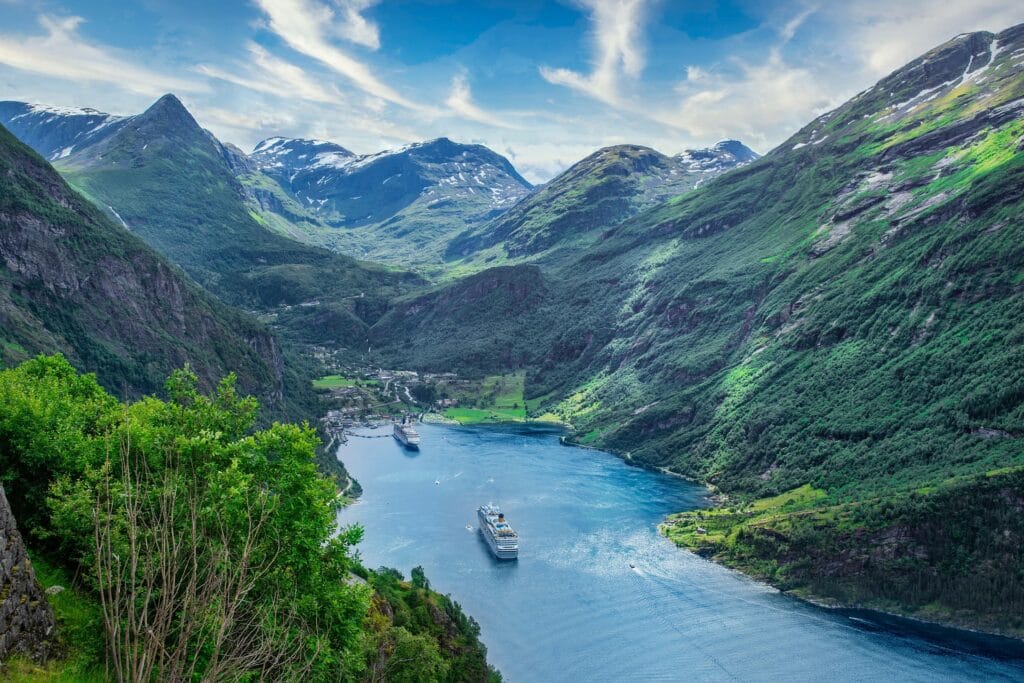 Cruise ships sailing through a stunning Mediterranean fjord, showcasing affordable luxury cruise routes in 2025.