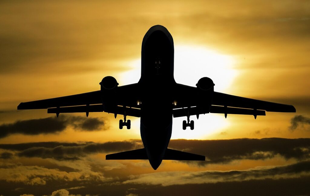 Airplane taking off at sunset, symbolizing affordable luxury travel through smarter ticket-buying strategies.