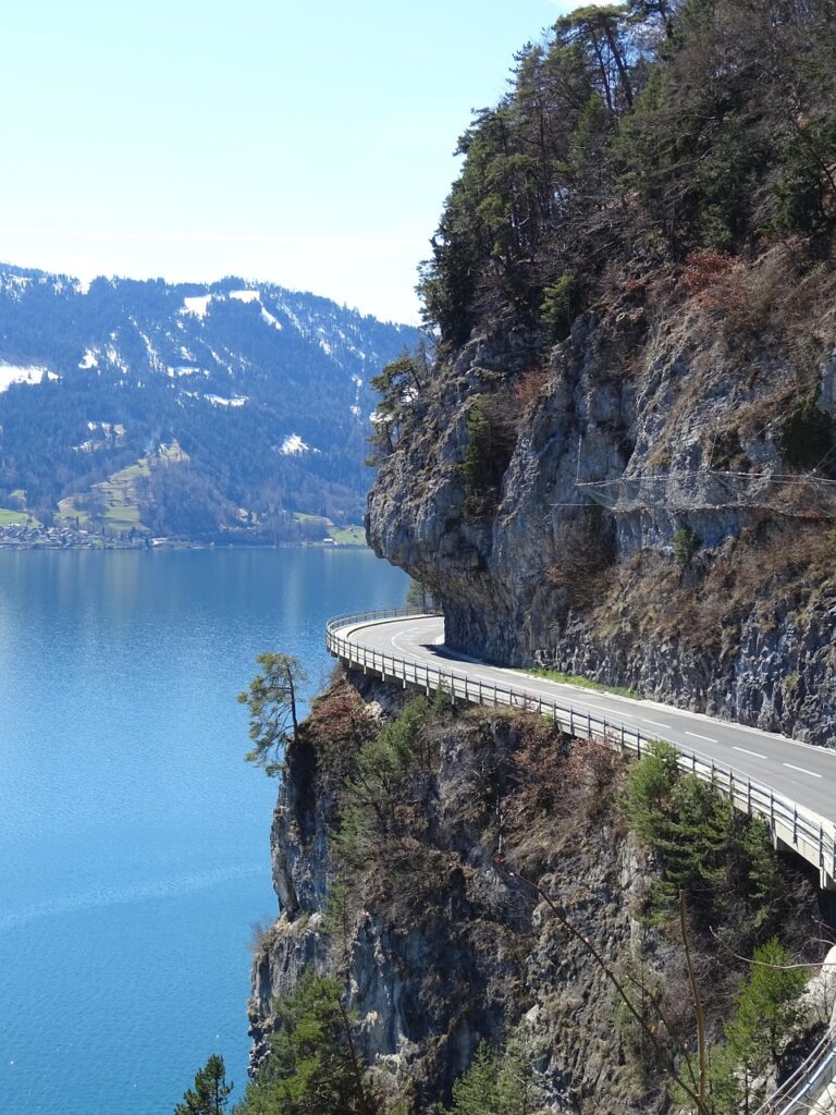Car driving on a Swiss mountain highway with vignette sticker on windshield Car driving on a scenic Swiss highway with mountains in the background and a vignette sticker on the windshield.