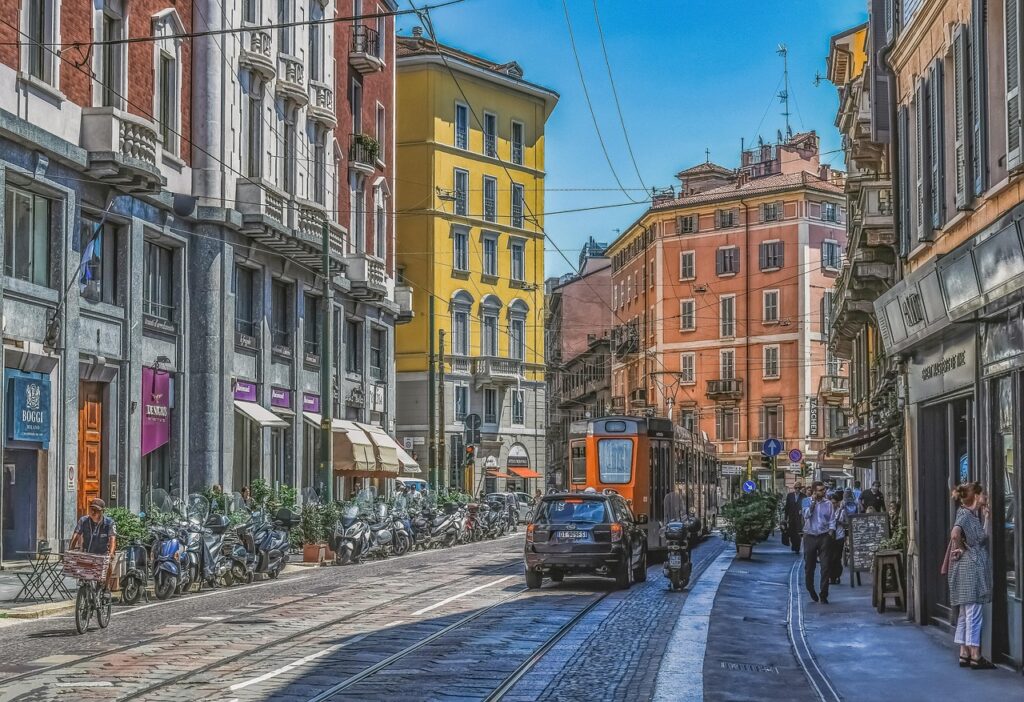 Evening in Milan’s Brera district with cobblestone streets, warm lights, and people enjoying aperitivo outdoors.