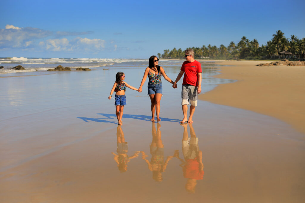 Bahia, Northeast Brazil — family-friendly beach day in the shoulder season We walking hand in hand on a calm palm-lined beach in Bahia, Northeast Brazil, on a clear shoulder-season morning