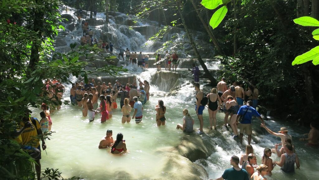 Families Climbing Dunn’s River Falls, Ocho Rios Visitors wading and holding hands on the terraced pools of Dunn’s River Falls in Ocho Rios, Jamaica—popular, kid-friendly waterfall with guides